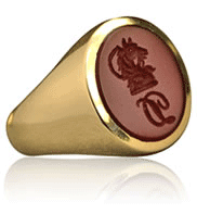 Gold signet ring set with cornelian gemstone and seal engraved with a crest and initial.